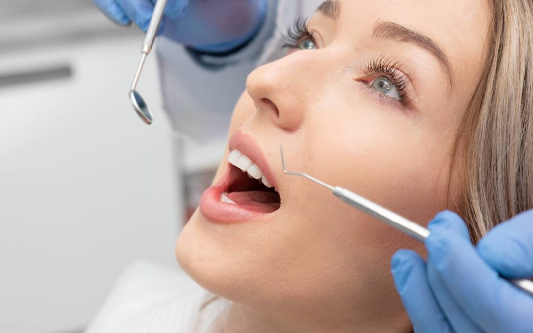 blonde woman's teeth being observed by dentist