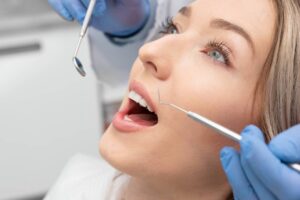 blonde woman's teeth being observed by dentist